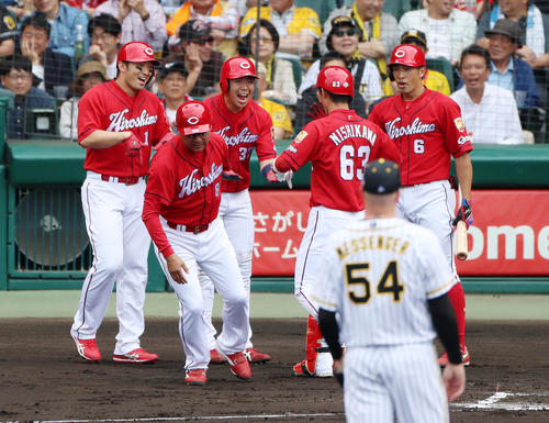 阪神対広島　1回表広島2死一、二塁、西川（背中）は右越え3点本塁打を放ち生還した左から、一走鈴木、1人おいて二走野間に笑顔で迎えられる、右は次打者安部（撮影・加藤哉）