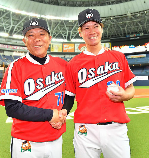 プロ初勝利を挙げ勝利球を手に西村徳文監督（左）と笑顔で握手を交わすＫ－鈴木（撮影・上田博志）