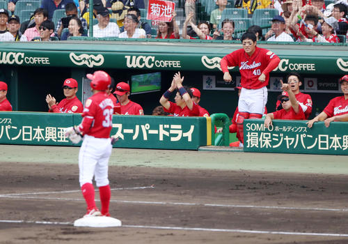 4回表広島2死一塁、菊池の右越え適時三塁打に笑顔を見せる緒方監督（左）とベンチのナインたち（撮影・加藤哉）