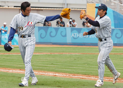 アテネ五輪　1次リーグ　イタリア対日本　ベンチ前で上原浩治（左）とハイタッチする宮本慎也（2004年8月15日撮影）
