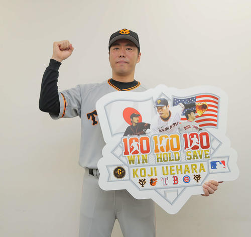 18年7月、日米通算100勝100セーブ100ホールドを達成し、ボードを掲げガッツポーズ
