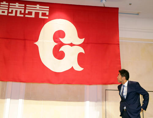 引退会見を終えて記念撮影をする直前、巨人の球団旗を見つめる上原（撮影・浅見桂子）
