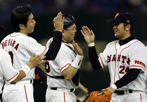 巨人対横浜　完封勝利の上原浩治（左）は笑顔で決勝本塁打の高橋由伸を迎える。中央は小田幸平（05年10月）