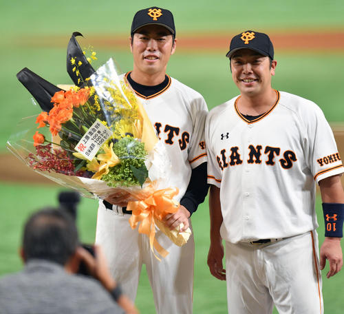 トリプル100達成記念セレモニーで巨人阿部（右）と記念撮影する上原（2018年7月29日撮影）