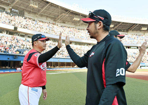 ロッテ対ソフトバンク　試合後、勝利投手のロッテ東條（手前）とタッチを交わす井口監督（撮影・滝沢徹郎）