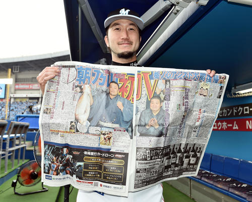 ロッテ対ソフトバンク　勝利投手のロッテ石川は同郷の朝乃山の優勝を伝える日刊スポーツを手に笑顔（撮影・滝沢徹郎）　