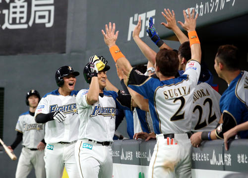 日本ハム対ロッテ　8回裏日本ハム2死一塁、逆転となる右越え2点本塁打を放ちチームメートに出迎えられる田中賢（撮影・佐藤翔太）