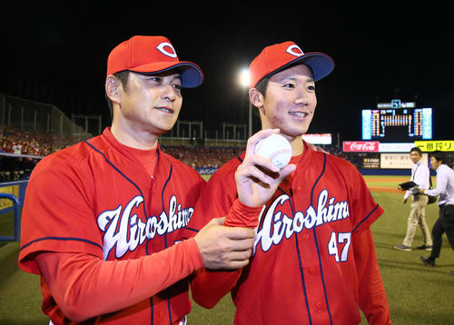 プロ初勝利を挙げた山口（右）は緒方監督と勝利球を手に笑顔（撮影・足立雅史）