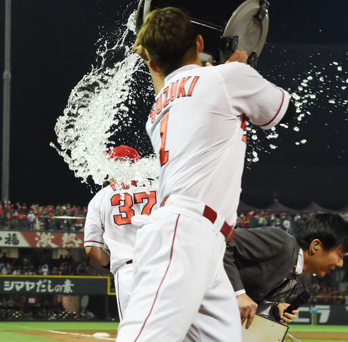 阪神にサヨナラ勝ち、ヒーローインタビューで鈴木誠也（手前）のウオーターシャワーをよける野間峻祥（撮影・奥田泰也）