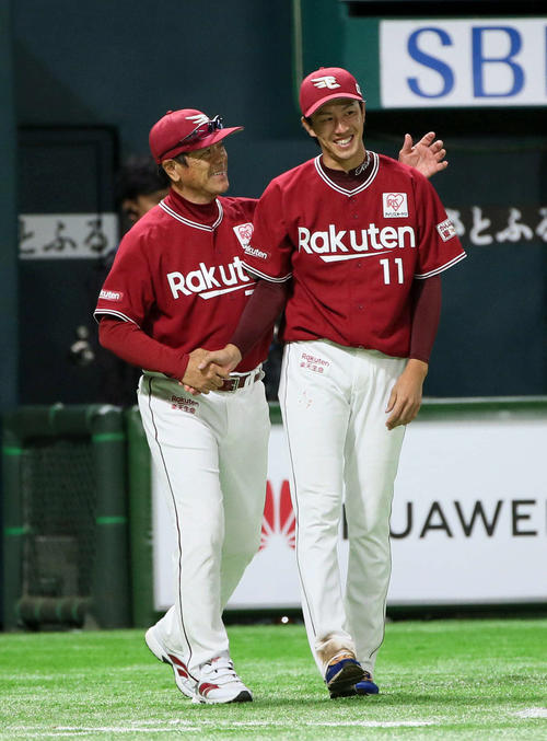 真喜志コーチ（左）と笑顔で握手を交わす岸（撮影・栗木一考）