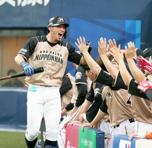 9回表日本ハム無死一、二塁、左越え3点本塁打放ちナインに出迎えられる大田（撮影・黒川智章）