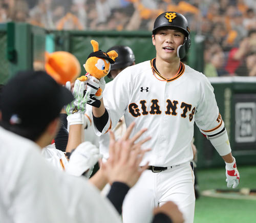 巨人対中日　5回裏巨人無死一塁、勝ち越しの左越え2点本塁打を放ちナインの出迎えを受ける坂本勇（右）（撮影・垰建太）