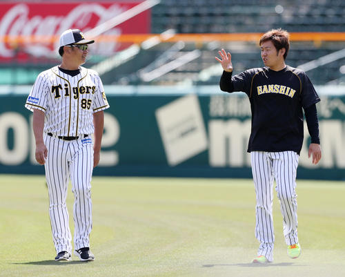 練習中、福原投手コーチ（左）と言葉を交わす西（撮影・前田充）