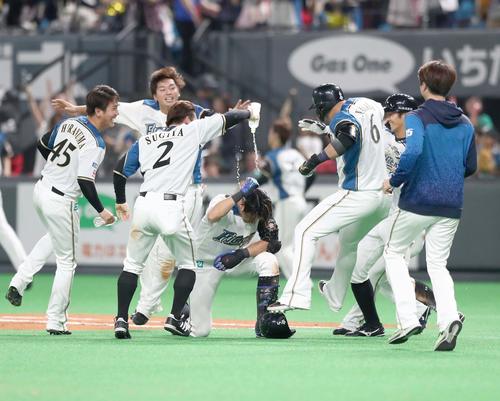 日本ハム対ヤクルト　10回裏日本ハム1死二、三塁、サヨナラ中犠飛を放った大田（中央）はナインから水をかけられ祝福される（撮影・黒川智章）