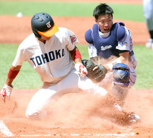 東北福祉大対佛教大　1回表東北福祉大1死三塁、本塁で憤死する里見（左）。捕手は坪倉（撮影・大野祥一）