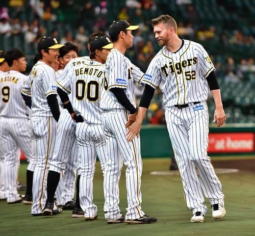 阪神対日本ハム　試合前に表彰を受けチームメートとタッチを交わすジョンソン（撮影・清水貴仁）