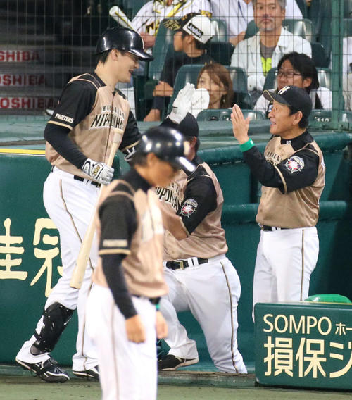 阪神対日本ハム　5回表日本ハム1死一塁、栗山監督（右）は送りバントを決めた有原を笑顔で迎える（撮影・上山淳一）