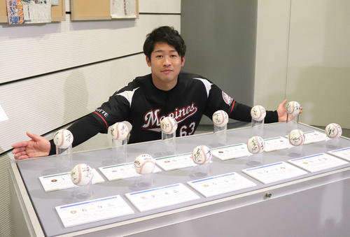 平成最後の記念球と令和最初の記念球を前に笑顔でポーズをとるロッテ種市（撮影・久永壮真）