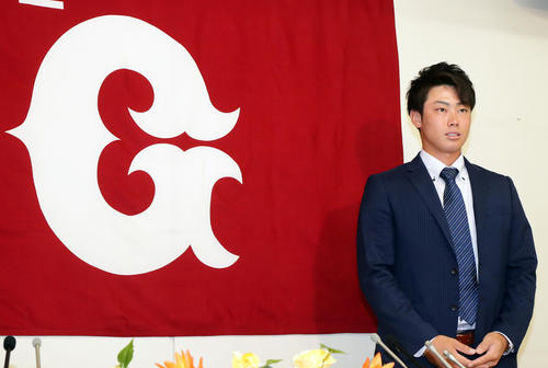支配下登録会見で、Gマークの横で抱負を述べる加藤脩平（撮影・浅見桂子）