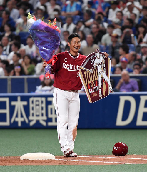 中日対楽天　5回表楽天1死満塁、右前適時打で通算1000安打を達成した銀次は花束とボードを手に笑顔を見せる（撮影・前岡正明）