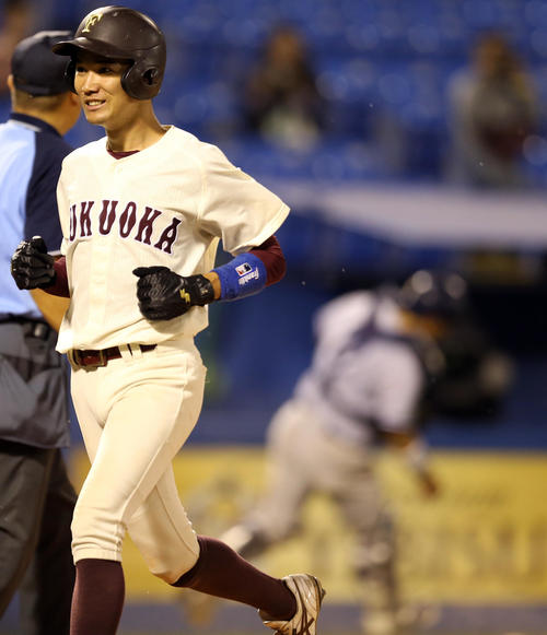 福岡大対星槎道都大　延長タイブレーク11回表福岡大2死一、三塁、暴投で生還する宮田（左）。捕手は松田（撮影・大野祥一）