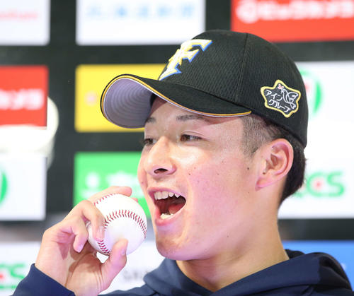 日本ハム対広島　プロ初登板初勝利を挙げ日本ハム吉田輝はウイニングボールをガブリ（撮影・井上学）