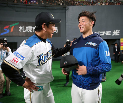 日本ハム対広島　プロ初登板初勝利を挙げ栗山監督（左）と笑顔で話す日本ハム吉田輝（撮影・井上学）