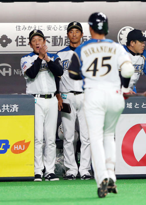 日本ハム対広島　2回裏日本ハム無死一、二塁、犠打を決めた平沼（手前）に拍手を送る栗山監督（左）（撮影・垰建太）