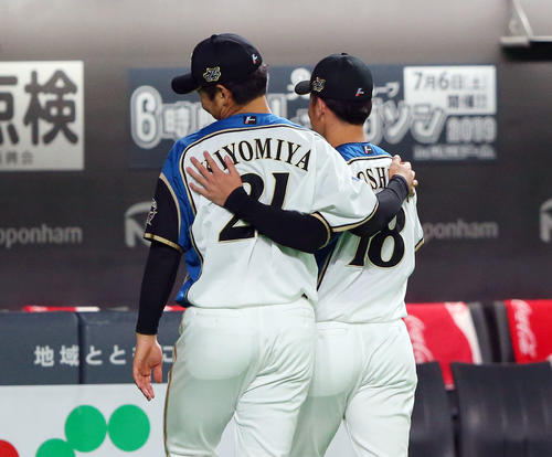 日本ハム対巨人　試合前、ファンとのハイタッチを終えた日本ハム吉田輝星（右）と清宮幸太郎は肩を組んで引き揚げる（撮影・垰建太）