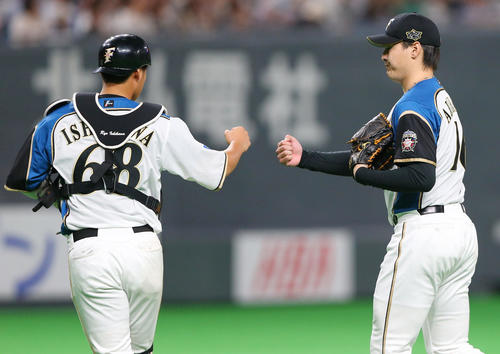 日本ハム対巨人　8回表巨人2死、大城を二ゴロに仕留めグータッチを交わす有原（右）と石川亮（撮影・垰建太）