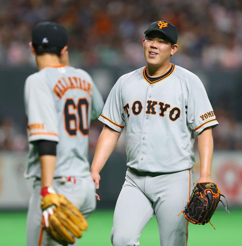 日本ハム対巨人　7回裏日本ハム2死一、二塁、大田を二ゴロに仕留めた山口（右）は引き揚げる途中若林から後逸を謝られ笑顔を見せる（撮影・垰建太）