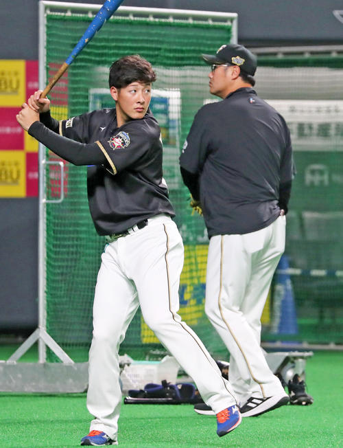 試合前、真剣な表情で素振りする日本ハム吉田（左）。右は木田コーチ（撮影・垰建太）