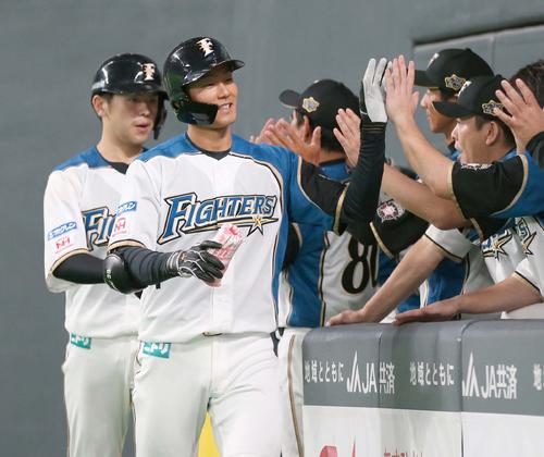 日本ハム対巨人　9回裏日本ハム無死一、三塁、右越え3点本塁打を放ちナインに出迎えられる石井（撮影・黒川智章）