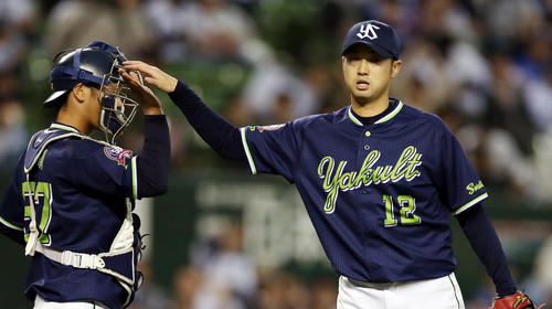 試合後、古賀（左）とタッチを交わす石山（撮影・狩俣裕三）