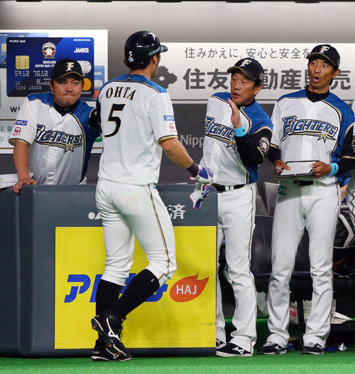 日本ハム対巨人　1回裏日本ハム無死一、三塁、中田の適時打で生還した大田を出迎える栗山監督（右から2人目）（撮影・垰建太）