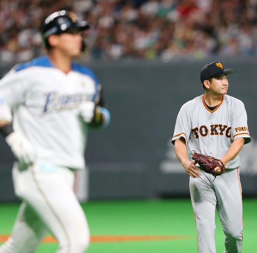 日本ハム対巨人　5回裏日本ハム2死、中田（左）を左飛に仕留めグラブをたたく菅野（撮影・垰建太）