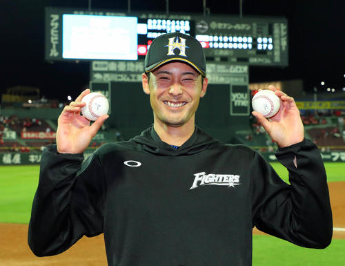 18年6月、広島戦で日本ハム上原は左手に本塁打球、右手に勝利球の2つの記念球を手に笑顔を見せる