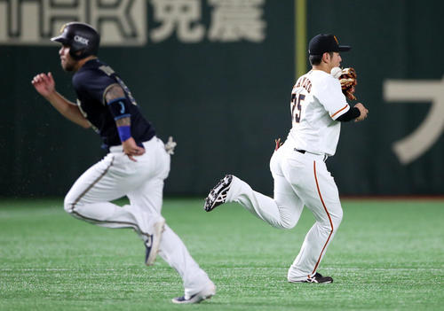 巨人対オリックス　4回表オリックス2死二、三塁、中川の打球をファンブルし、失点を許す岡本（右）。左はロメロ（撮影・狩俣裕三）