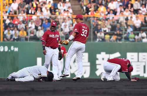 阪神対楽天　1回裏阪神2死一、二塁、挟殺プレーで激突し倒れ込む大山（左）と浅村（撮影・上田博志）