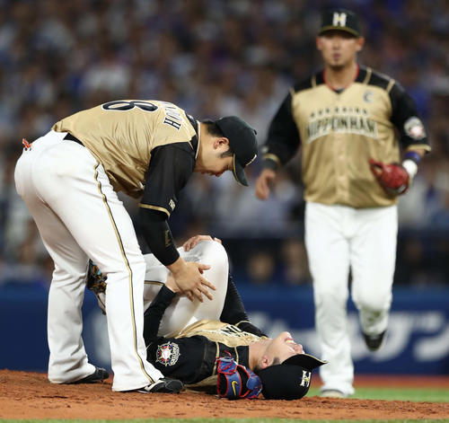 DeNA対日本ハム　6回裏DeNA2死、ソトの打球を左膝に受けてもん絶する上沢（中央）と心配そうに駆け寄る近藤（左）ら（撮影・黒川智章）
