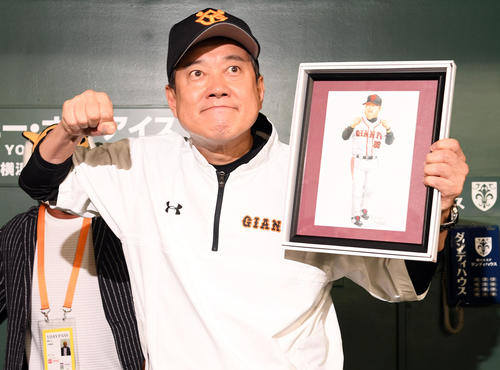 イラストレーターの坂井永年氏から贈られた自画像を手にポーズを決める巨人原監督（撮影・たえ見朱実）