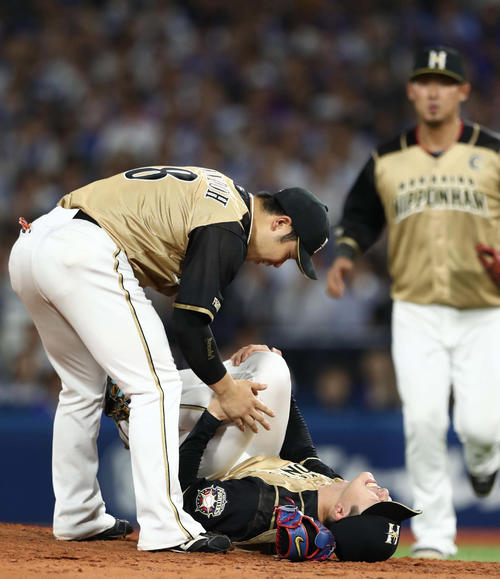 DeNA対日本ハム　6回裏、ソトの打球を左膝に受けてもん絶する上沢（中央）と心配そうに駆け寄る近藤（左）ら（撮影・黒川智章）