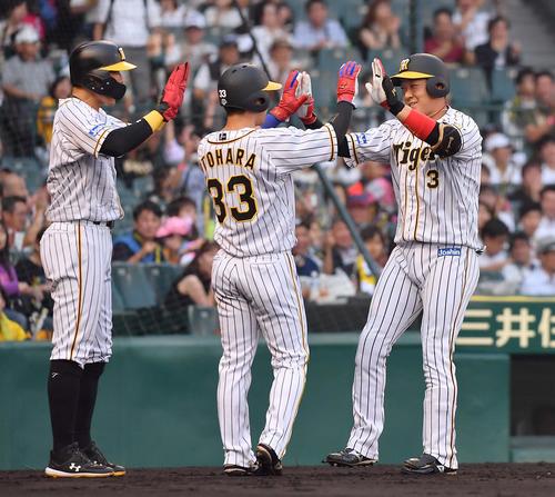 1回裏阪神1死一、二塁、左越え先制3点本塁打を放った大山は（左から）糸井、糸原に迎えられる（撮影・上田博志）