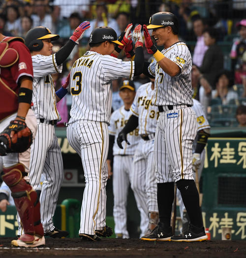 1回裏阪神1死一、二塁、大山は左越え3点本塁打を放ち糸井とタッチを交わす（撮影・奥田泰也）
