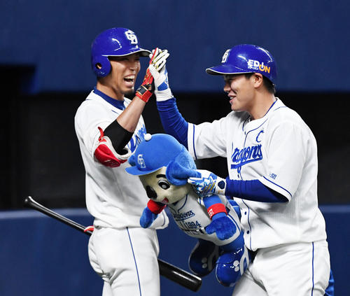 中日対日本ハム　1回裏中日2死一、二塁、右中間へ先制の3点本塁打を放った高橋（右）は藤井と笑顔でタッチ（撮影・前岡正明）