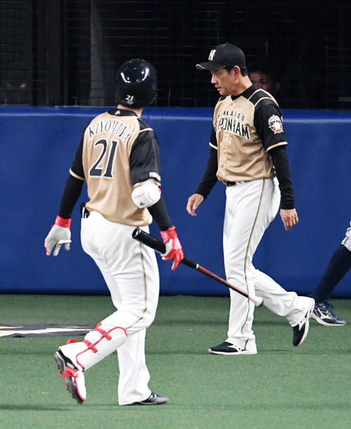 中日対日本ハム　6回、交代を告げるためベンチを出た栗山監督（右）。左は清宮（撮影・前岡正明）