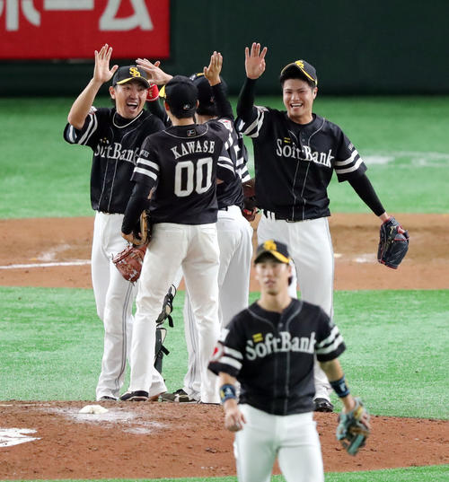 巨人対ソフトバンク　9回裏巨人2死、阿部を打ち取り最後を締めた甲斐野（右奥）は笑顔でナインとタッチを交わす（撮影・垰建太）