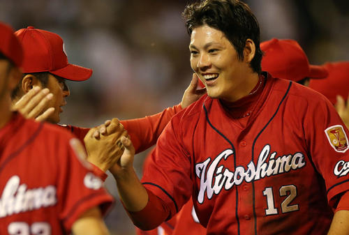 楽天対広島 試合後、プロ初完封で勝利を納め、緒方監督(左)とタッチを交わす九里(撮影・狩俣裕三)