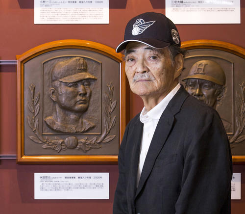 レリーフの前に立つ米田哲也氏（撮影・上山淳一）