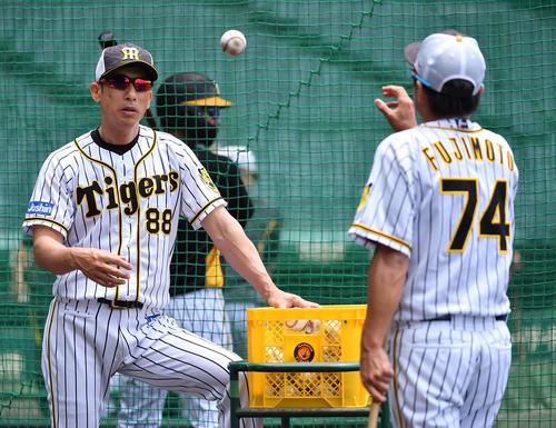 藤本コーチ（右）にボールを渡す矢野監督（撮影・上田博志）